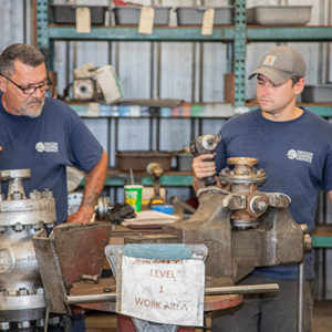 two men working on a valve